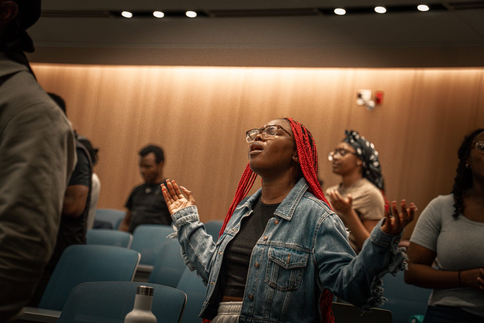Hands raised in an auditorium during a worship night