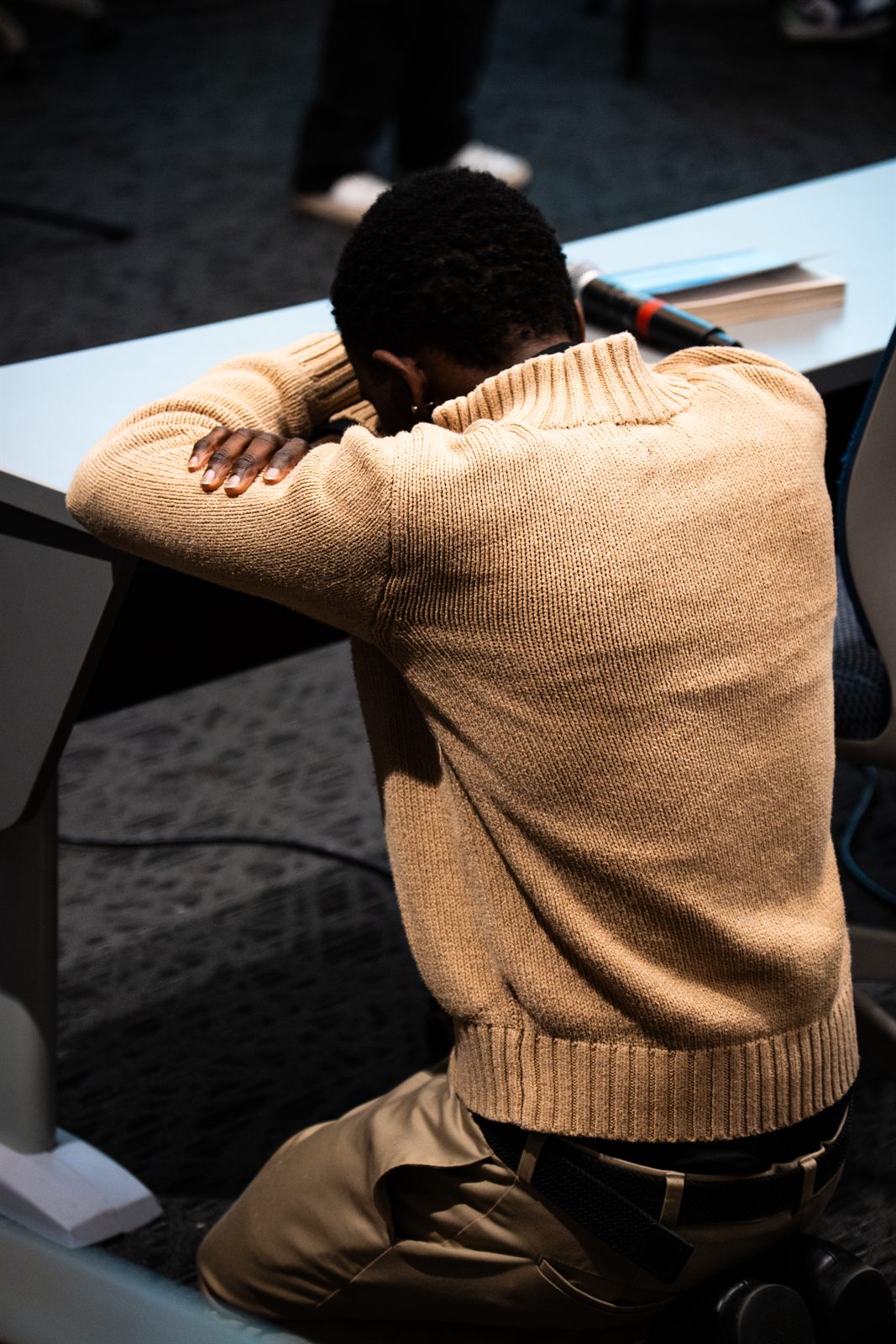 Attendee kneeling in a quiet moment during the gathering