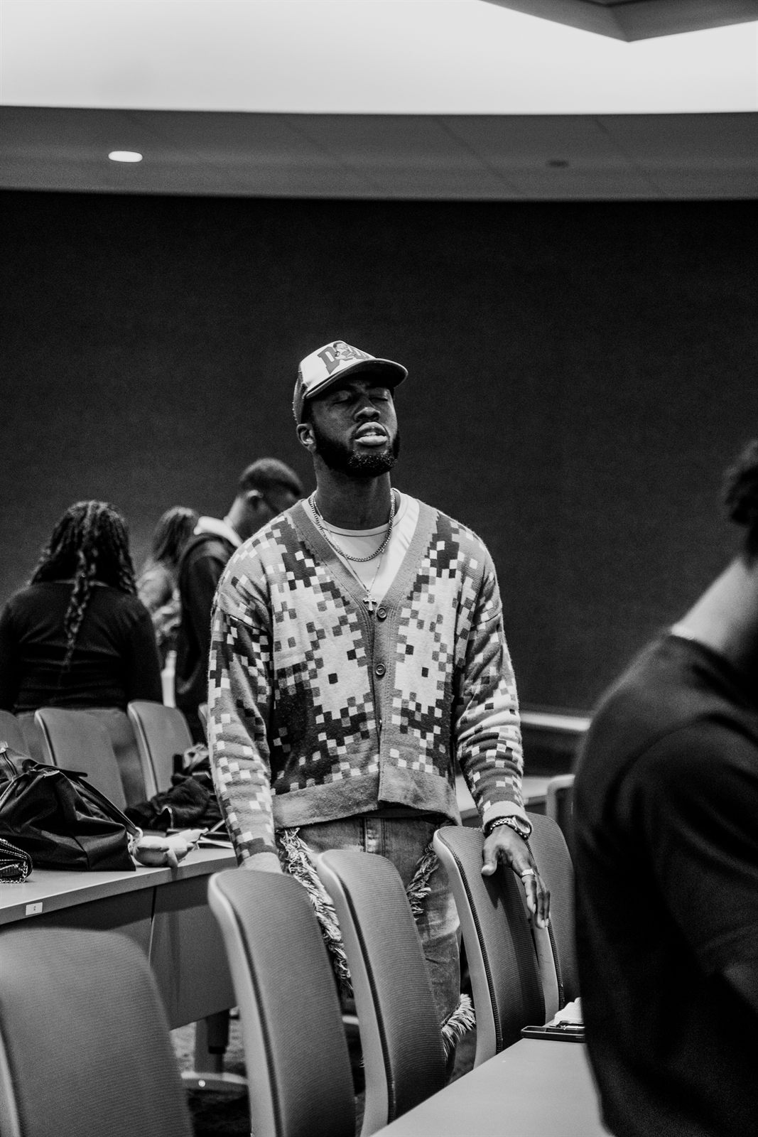 Black and white portrait of an attendee standing in the seating