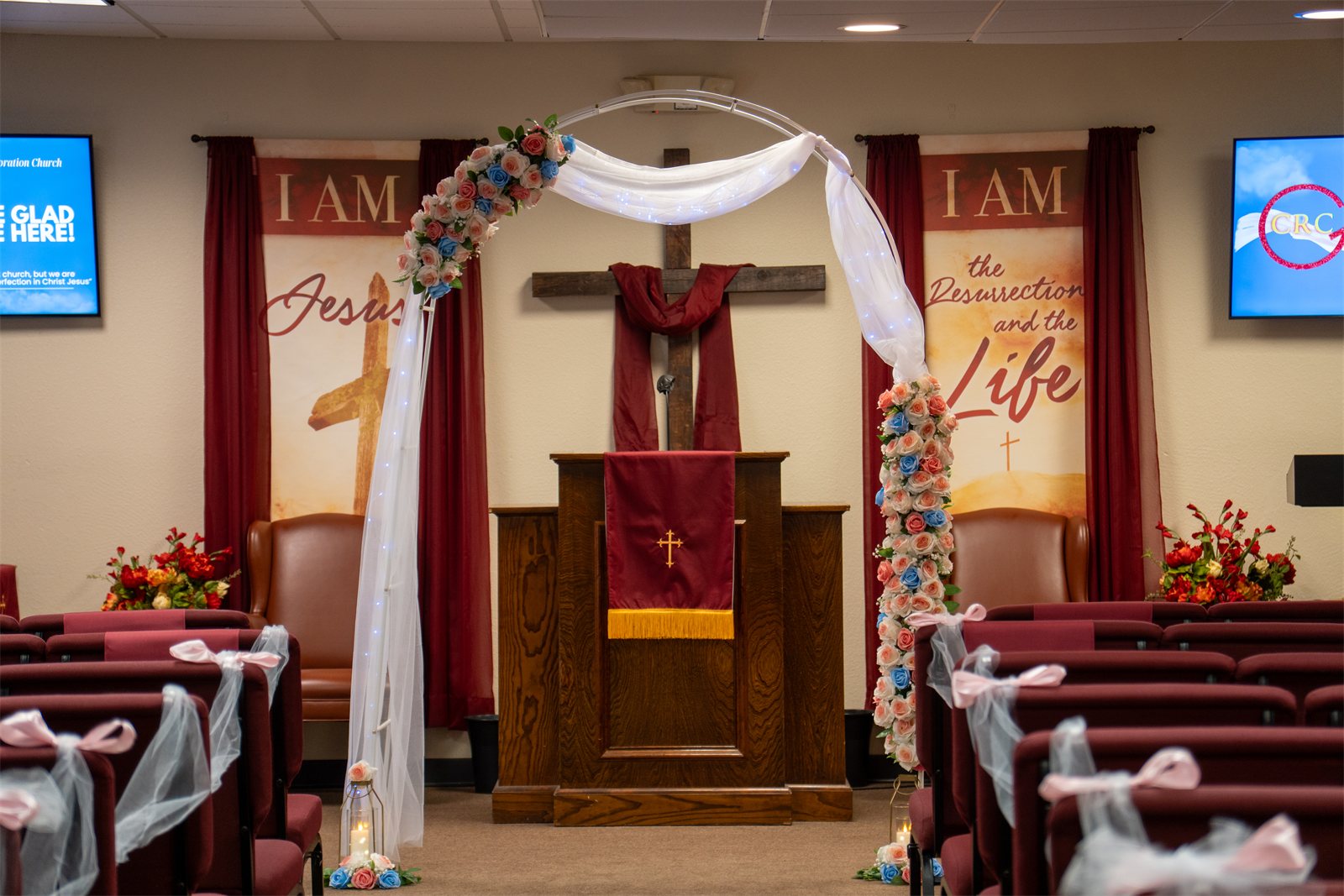 Sanctuary dressed for the ceremony with floral arch and draping